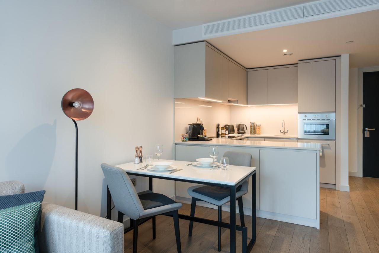 Citysuites Aparthotel Salford  Exterior photo The photo shows a modern and stylish kitchen and dining area. The kitchen features sleek cabinets with a subtle color palette and built-in appliances, including an oven and possibly a stovetop. A countertop is visible, with kitchen utensils and small