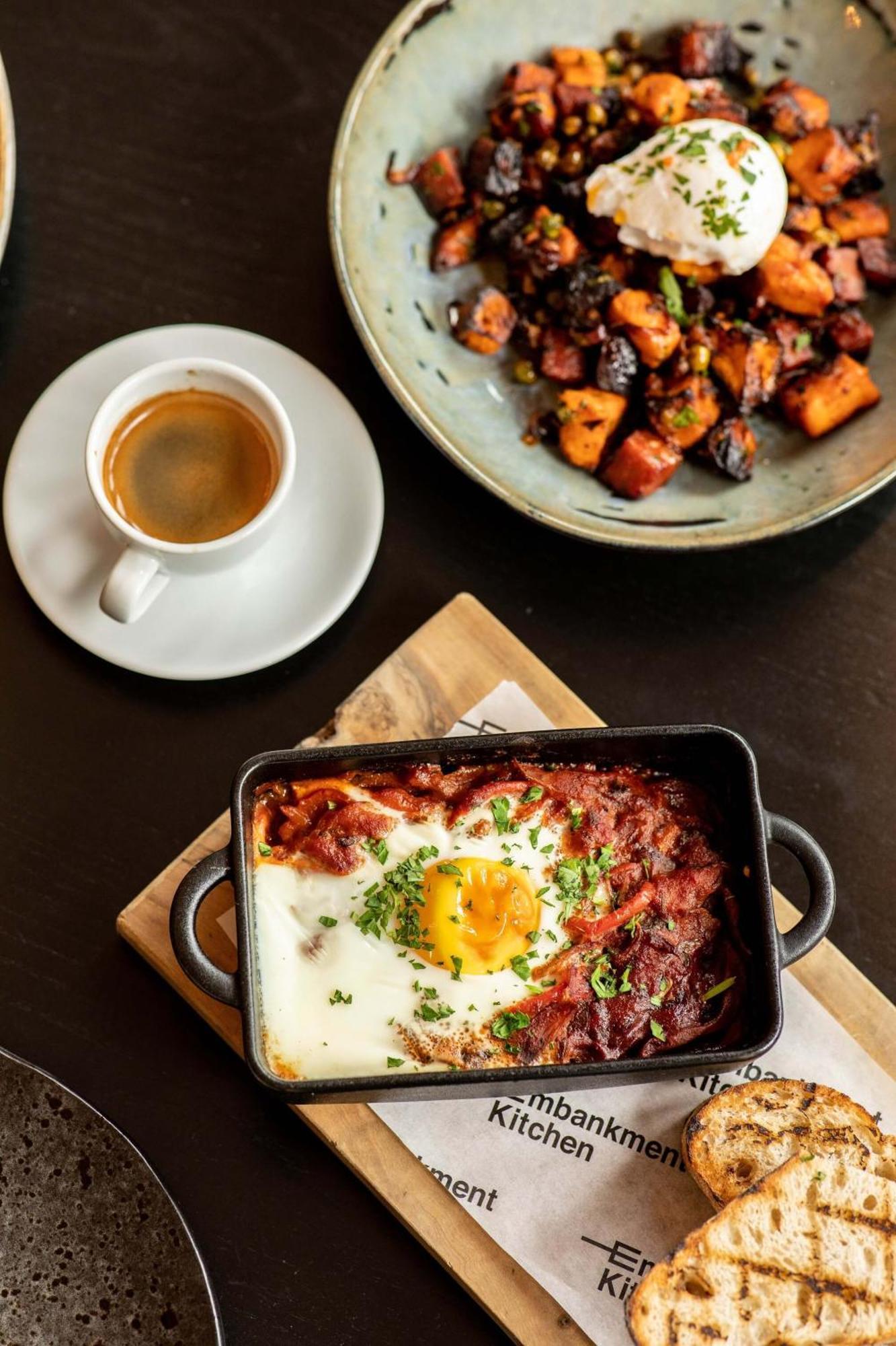 Citysuites Aparthotel Salford  Exterior photo The photo features a plate of food that includes a baked dish with a sunny-side-up egg on top, surrounded by a rich, tomato-based sauce, and garnished with chopped herbs. Next to it, there are roasted or grilled vegetables, likely sweet potatoes or s