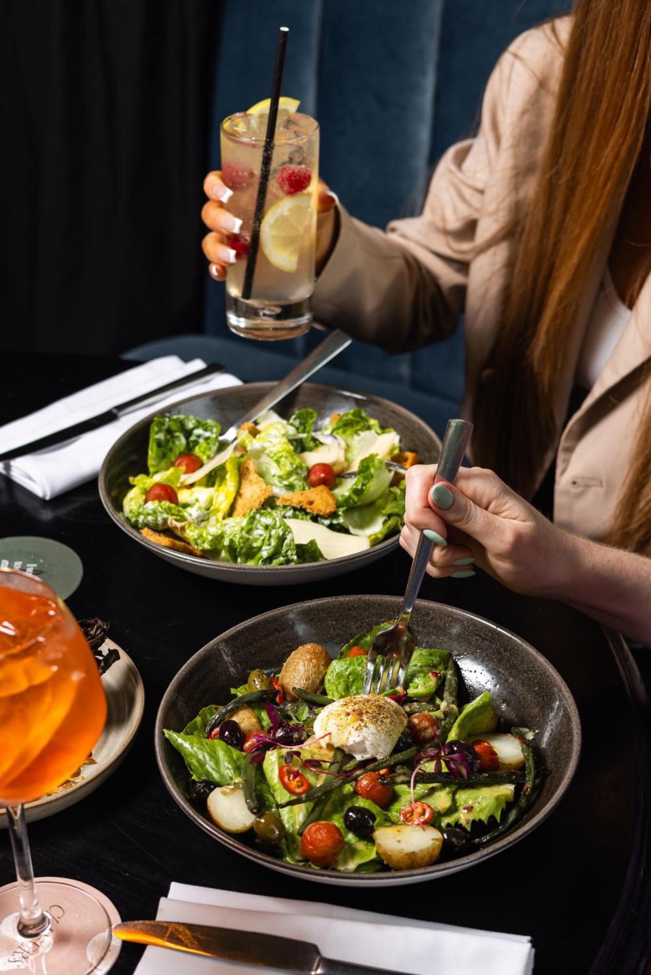 Citysuites Aparthotel Salford  Exterior photo The photo shows a dining scene with two dishes on a table. One bowl contains a vibrant green salad with romaine lettuce, cherry tomatoes, and possibly other fresh ingredients. The other bowl features a mixed salad with various colorful vegetables and