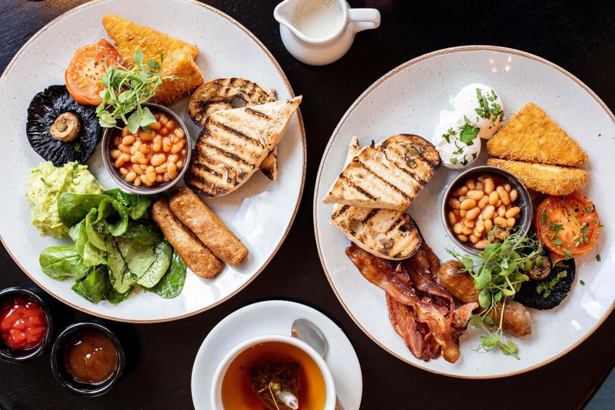 Citysuites Aparthotel Salford  Exterior photo The photo displays two plates of breakfast food. Each plate has a variety of items, including:

- Grilled slices of bread
- Beans served in a small bowl
- Grilled sausages
- Sliced tomatoes
- Sautéed greens or salad
- A portion of golden-brown fried 
