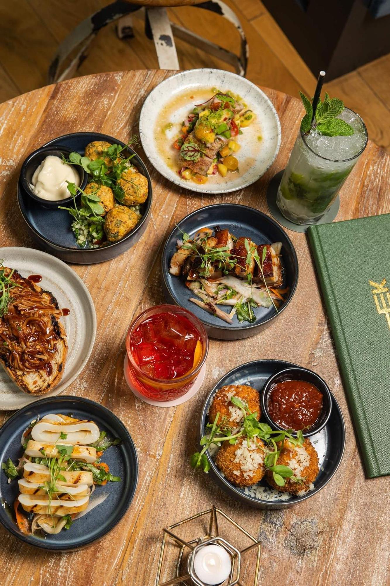 Citysuites Aparthotel Salford  Exterior photo The photo displays a colorful assortment of dishes served on dark plates and bowls, arranged on a wooden table. There are several small dishes featuring different types of food, including:

1. **Fried items** - Likely some sort of croquettes or balls